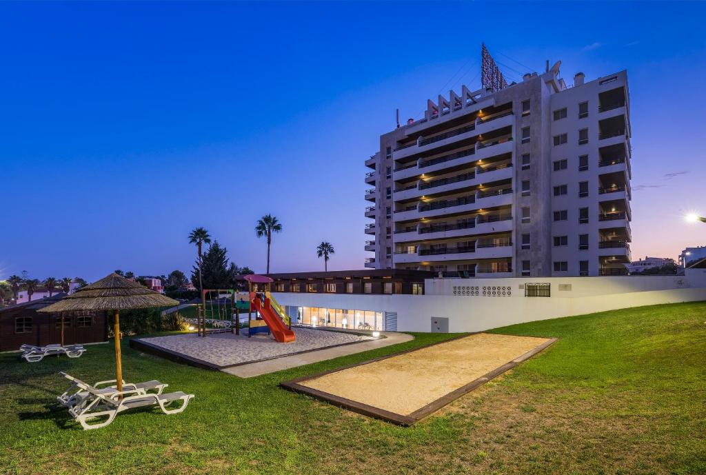 a large building with a playground in front of it at Interpass Vau Hotel Apartamentos in Portimão