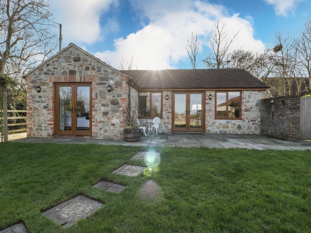 a stone house with a lawn in front of it at The Hide in Bridgwater