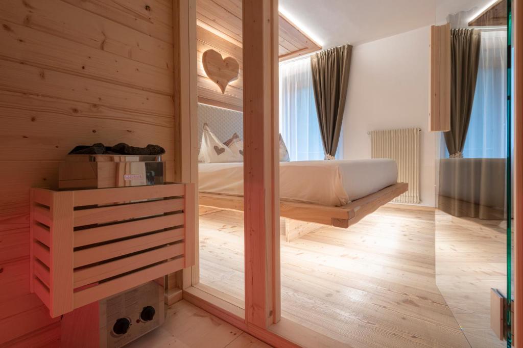 - une chambre avec un lit et un miroir dans l'établissement Baita Velon, à Vermiglio