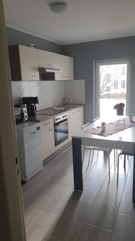 a kitchen with white appliances and a table in it at Flensburg Mitte 38 in Flensburg