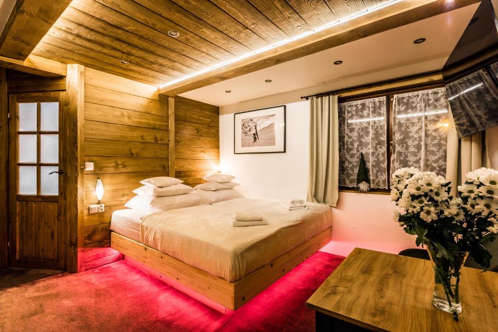 a bedroom with a large bed and a wooden ceiling at Apartamenty Szymaszkowa in Zakopane