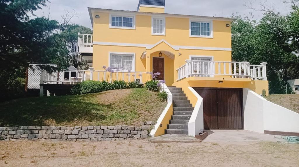 a yellow house with a staircase in front of it at La soñada in Mar Azul