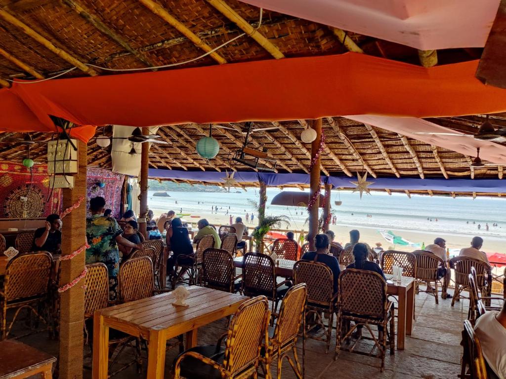 a group of people sitting at a beach restaurant at Rococo Pelton beach huts Palolem Beach goa in Palolem