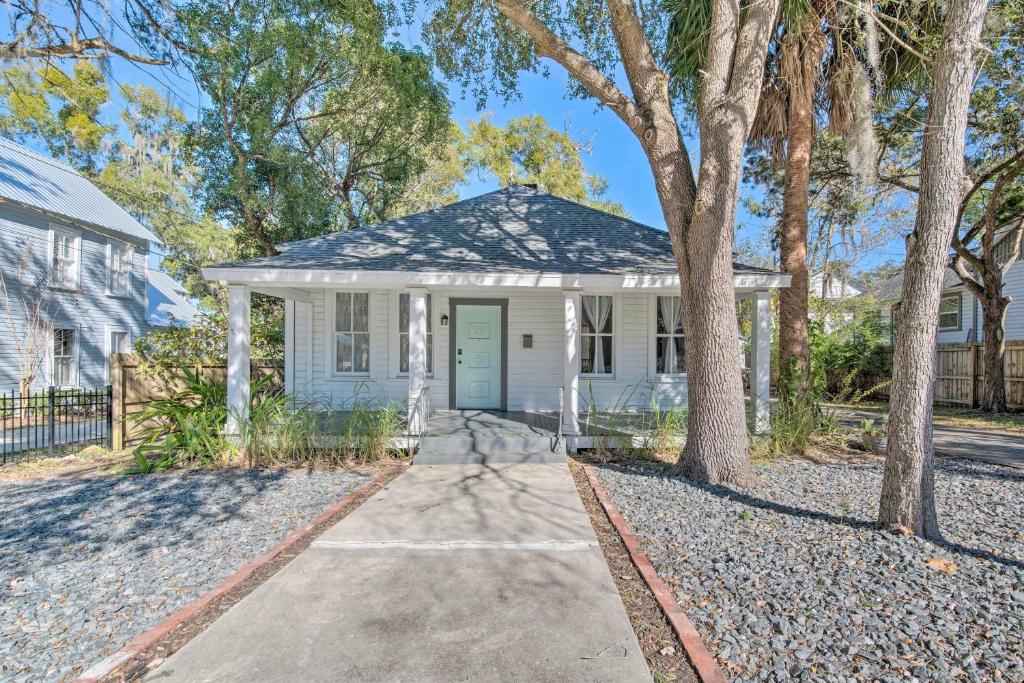 ein weißes Haus mit einer blauen Tür und Bäumen in der Unterkunft Charming 100-Year-Old Home Less Than 1 Mi to Downtown in Ocala