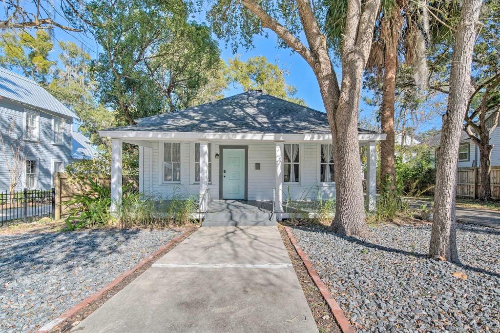 a white house with a blue door and trees at Charming 100-Year-Old Home Less Than 1 Mi to Downtown in Ocala