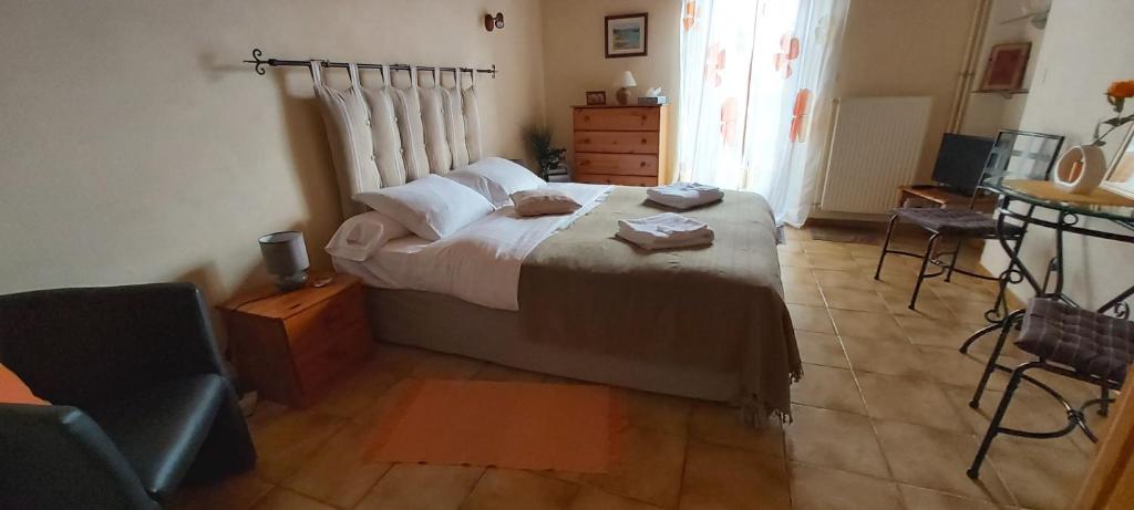 a bedroom with a bed and a chair in it at Chambres D'Hotes "Les Chiens Verts", jardin, terrasse, parking privé in Hauteville-Lompnes