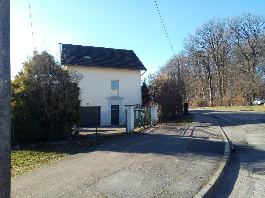 una casa bianca con un tetto nero su una strada di Maison chaleureuse Proche de Gerardmer a Épinal