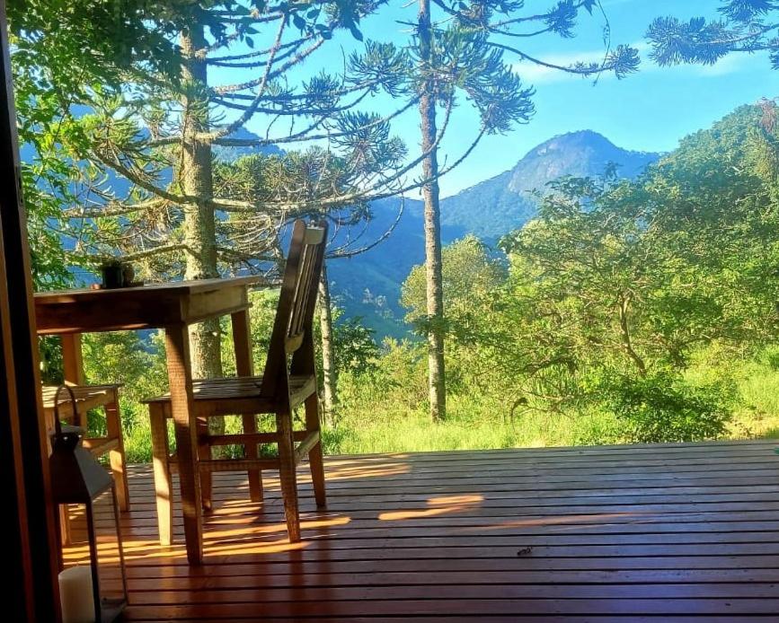 a chair on a porch with a view of a mountain at Cabana Arbosana in São Bento do Sapucaí
