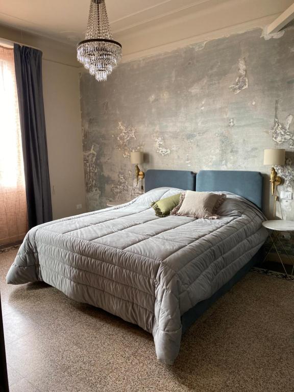 a bedroom with a large bed with a blue headboard at La Didì Maison in Bologna