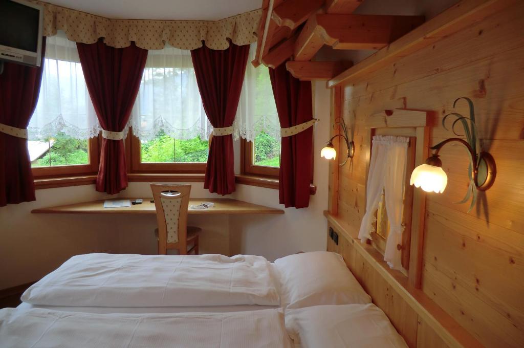 1 dormitorio con 1 cama frente a una ventana en Garnì Costa Verde en Bocenago