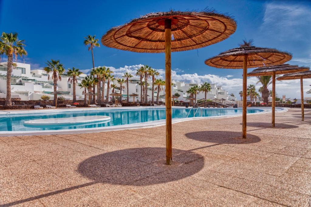 een groep parasols naast een zwembad bij N E W 2021 My-Lanza the Luxury ONE in Costa Teguise
