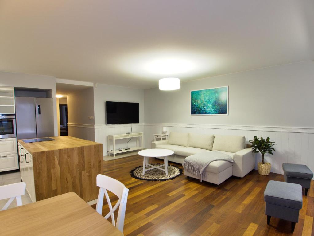 een woonkamer met een bank en een tafel bij Family Suite Parking 2 Bathrooms 300 m sea in Sopot