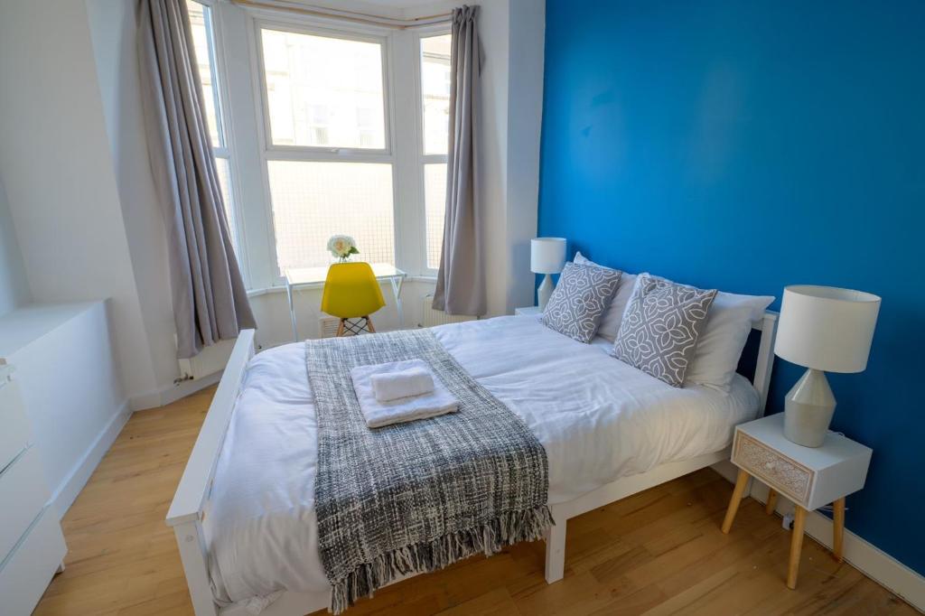 Dormitorio azul con cama y pared azul en Spacious 5 Bed House, perfect for groups, great location, en Liverpool