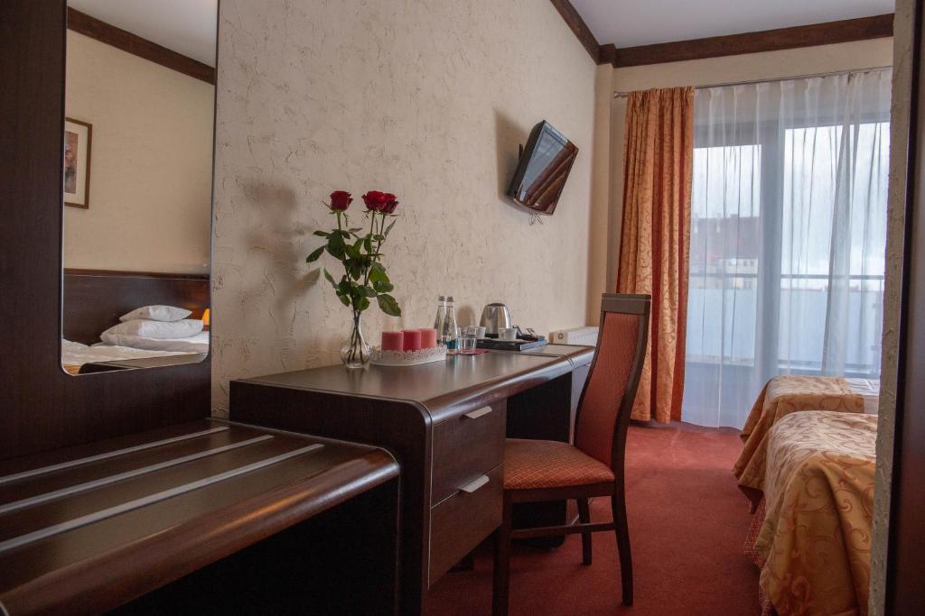 a hotel room with a desk and a bed at Neptun in Legnica