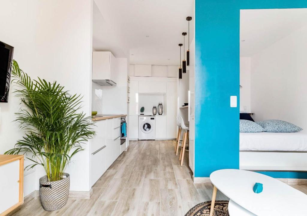 una cocina con armarios blancos y una pared azul en Les Bords de l'Estaque x Studio Braque en Marsella