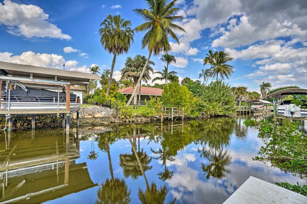 een huis naast een waterlichaam met palmbomen bij Sunny Naples Home with Pool, Direct Gulf Access in Naples