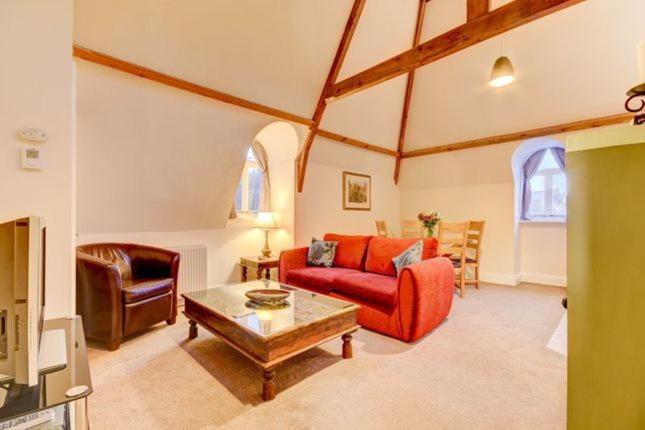 a living room with a red couch and a table at Sleepy Hollow in Whitby