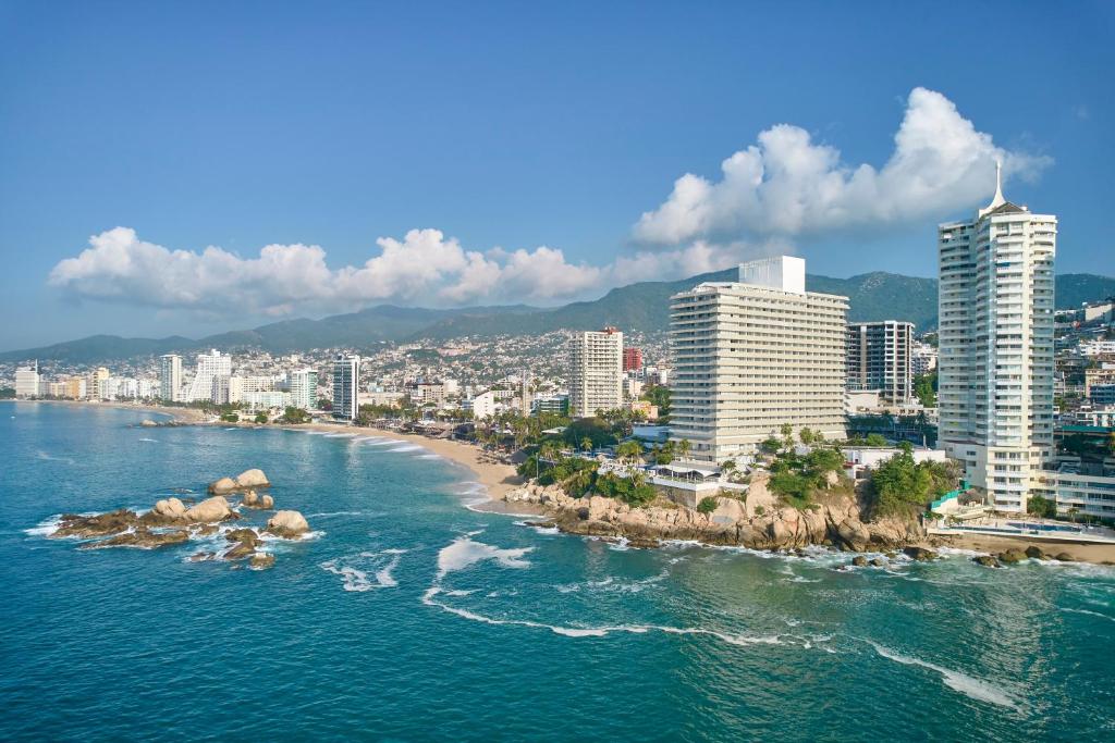 eine Luftansicht auf eine Stadt und einen Strand mit Gebäuden in der Unterkunft Fiesta Americana Acapulco Villas in Acapulco