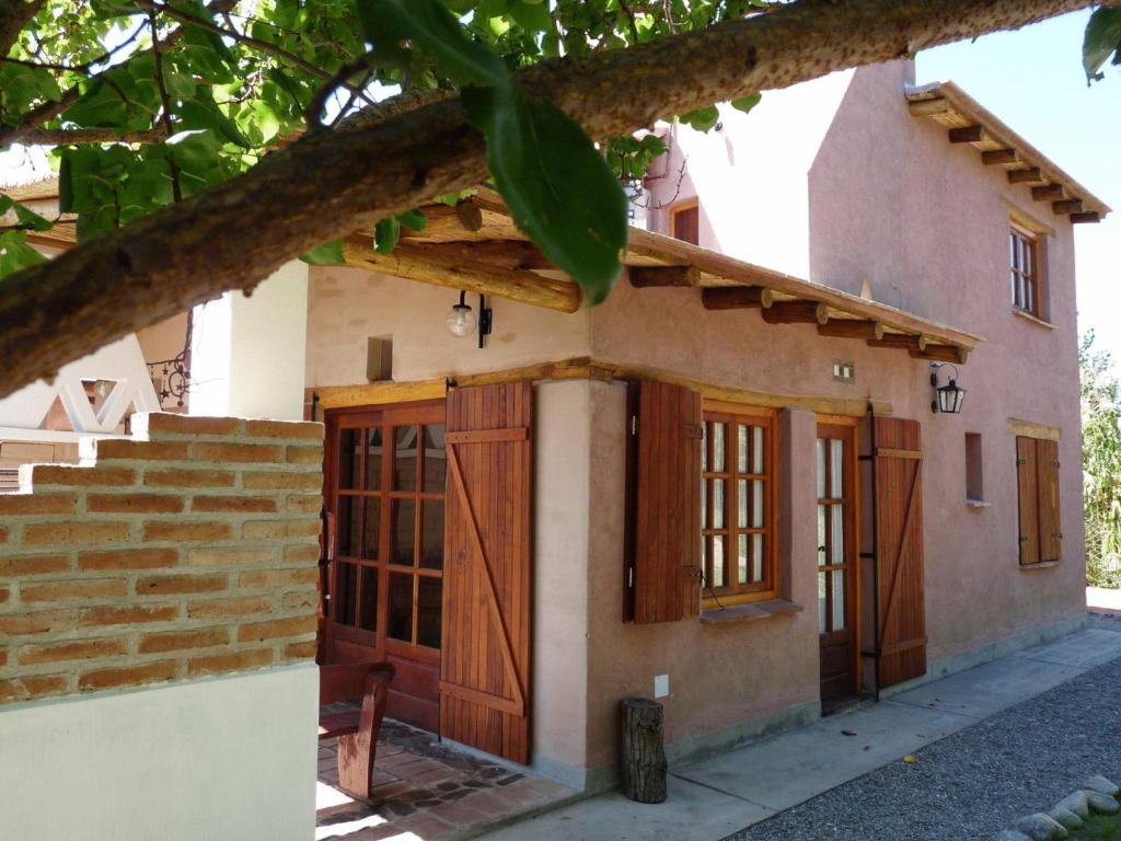 a small house with wooden doors and stairs at Cabañas Luna y Sol in Cafayate