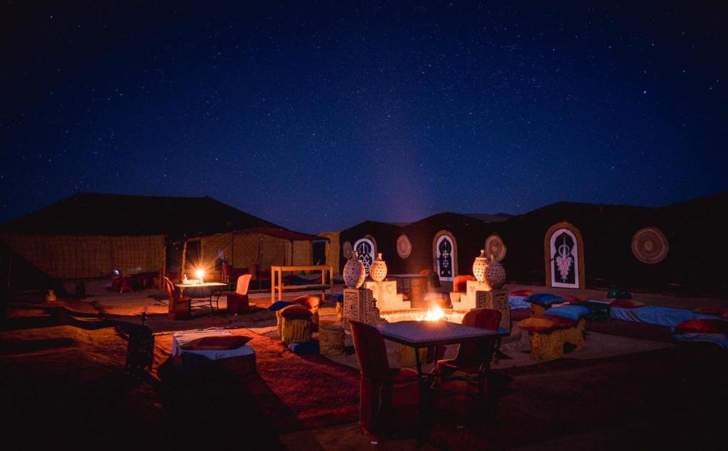 a night scene of a desert with a starry sky at Chegaga Nomad Camp in El Gouera