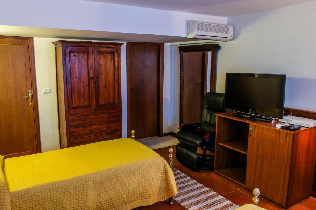 レッジョ・ディ・カラブリアにあるAl Cortilettoのベッドルーム(ベッド1台、テレビ、椅子付)