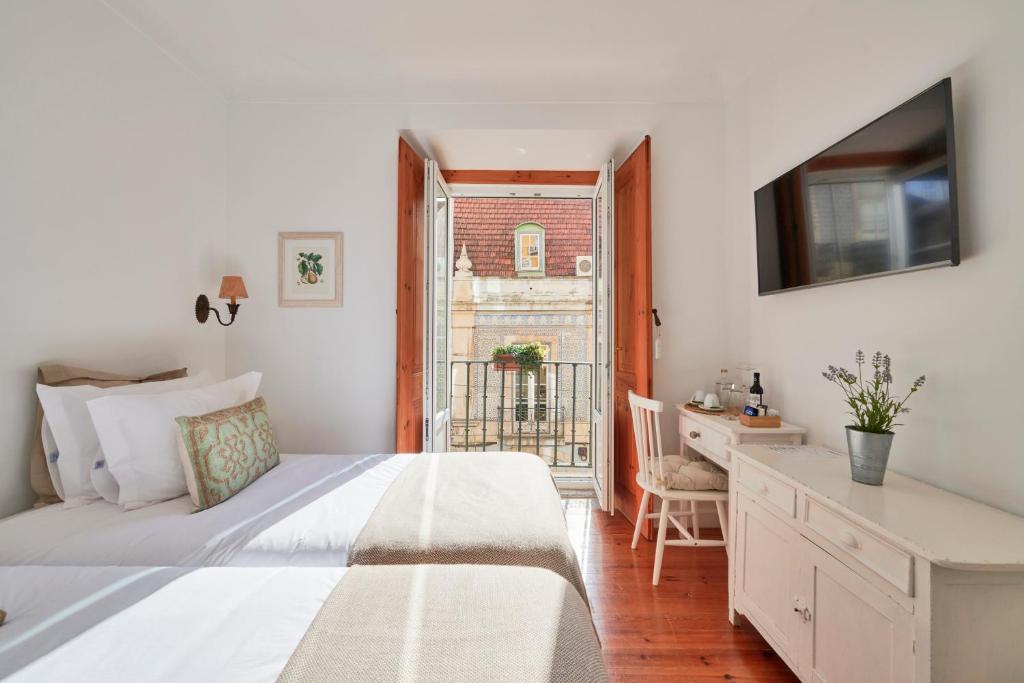 a bedroom with a bed and a desk and a window at Casa do Mercado Lisboa in Lisbon