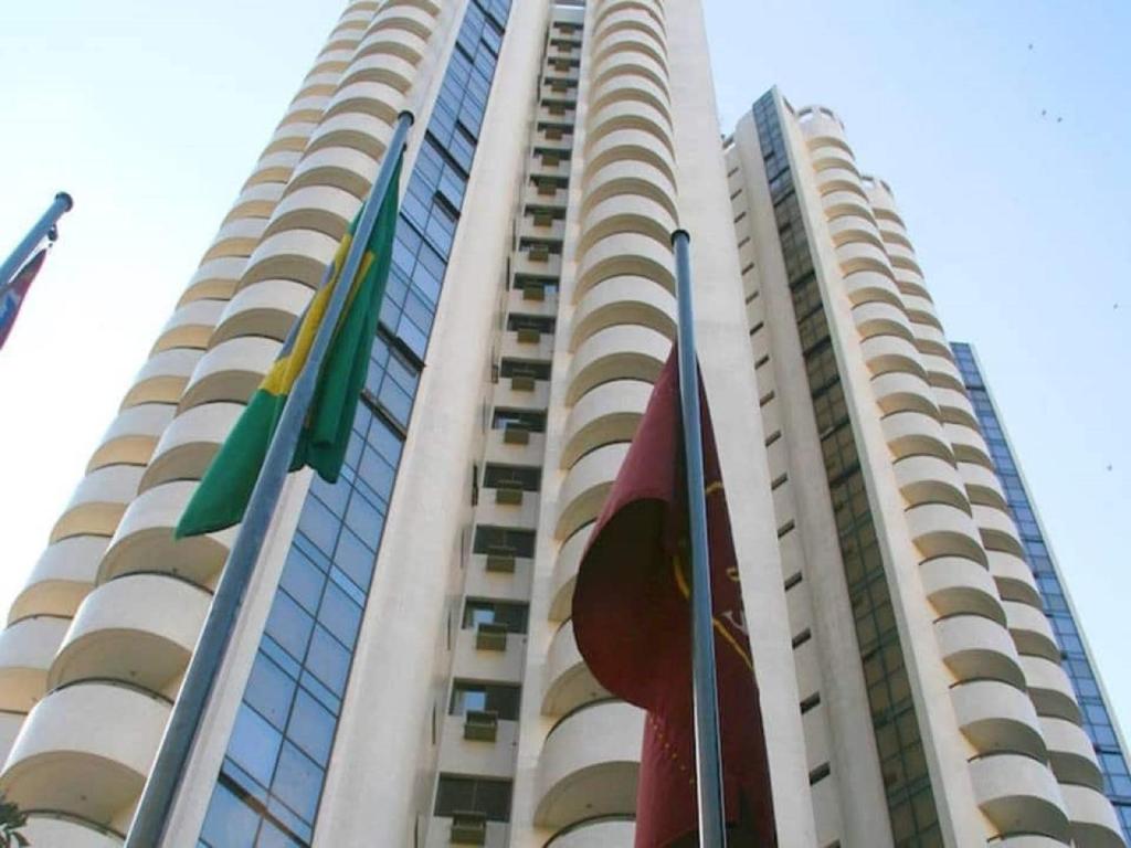 a tall building with flags in front of it at Paulista Wall Street Flat 03 in São Paulo