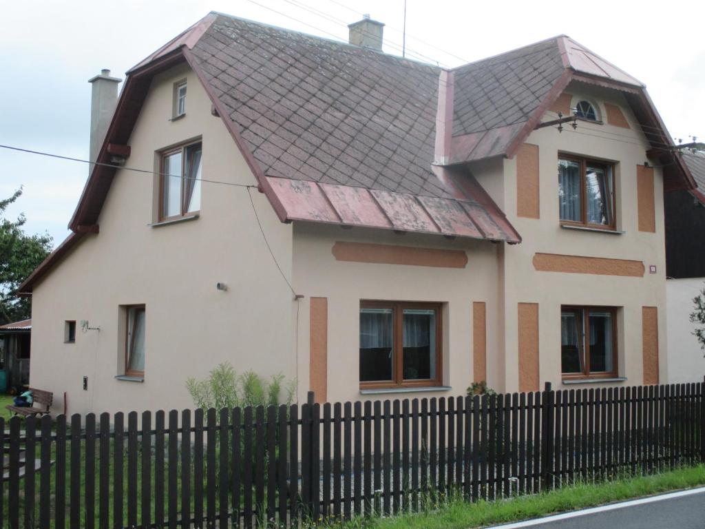 a white house with a black fence in front of it at Dům Hana in Nejdek