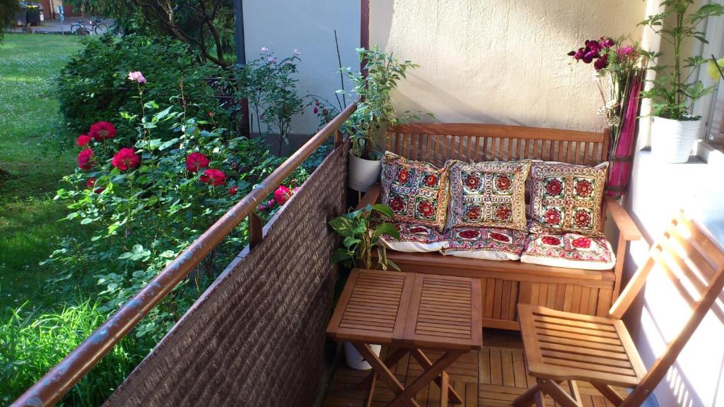 a balcony with a bench and pillows and flowers at Green Oasis in Berlin