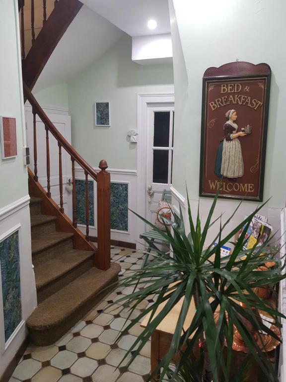 a staircase with a welcome sign in a house at Maison de Berry Bed & Breakfast in Villedieu-les-Poêles