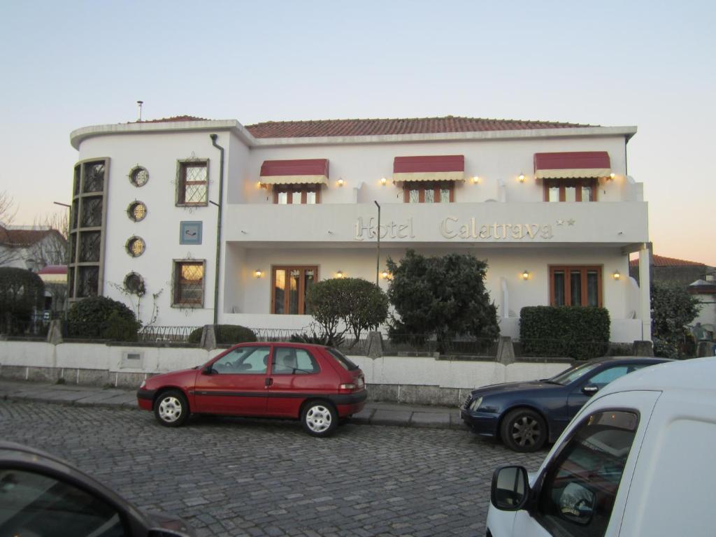 a red car parked in front of a white building at Hotel Calatrava in Viana do Castelo