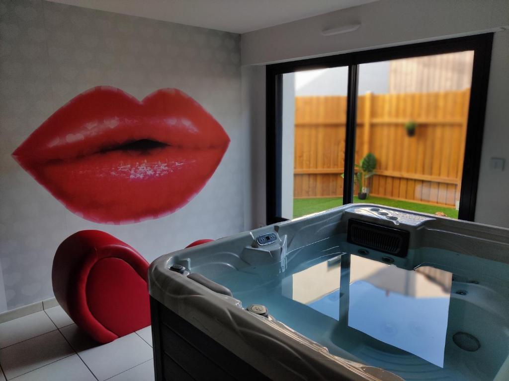 a red lips painting on a wall next to a sink at Centre historique de Clisson avec Spa Intérieur in Clisson