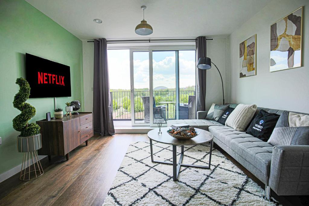 a living room with a couch and a table at Penthouse Apartment - City Centre - Free Parking, Balcony, Fast Wifi and Smart TV with Netflix by Yoko Property in Milton Keynes
