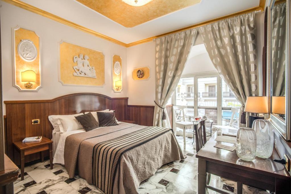 um quarto com uma cama, uma mesa e uma janela em Nakissa Inn em Roma