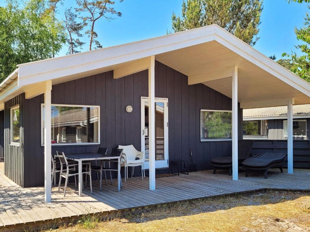 a house with a deck with a table and chairs at 8 person holiday home in Nex in Snogebæk