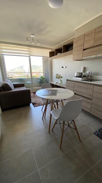 cocina y sala de estar con mesa y sillas en Apart Center Temuco, en Temuco