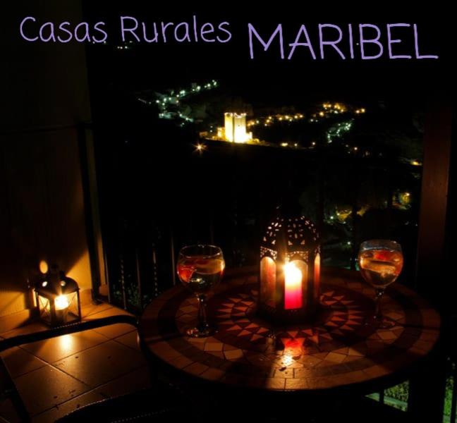 una mesa con 2 velas y copas de vino en el balcón en Casas El Tejar, en Casas del Cerro