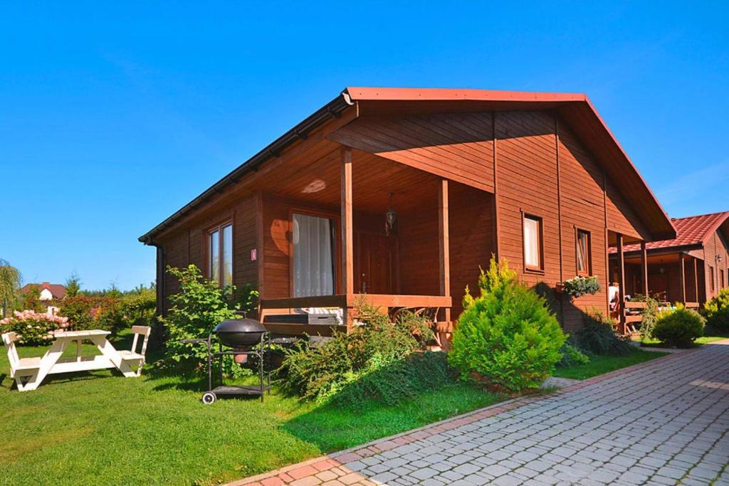 a small wooden house with a table and a grill at Holiday resort, Wicie in Wicie