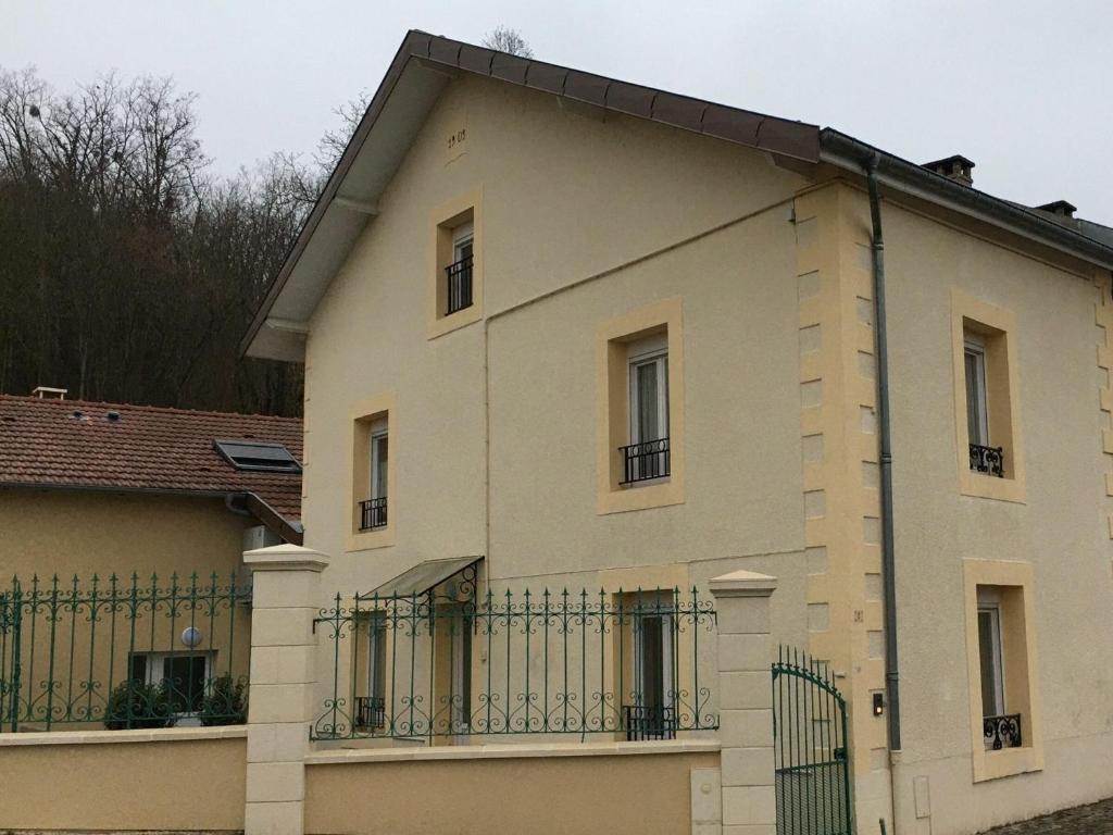 une grande maison blanche avec une clôture dans l'établissement Gîte Velle-sur-Moselle, 3 pièces, 5 personnes - FR-1-584-178, à Velle-sur-Moselle