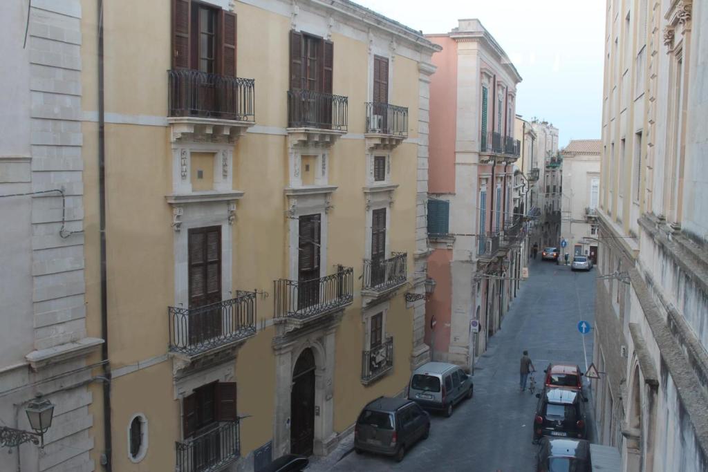 a city street with cars parked on the side of buildings at Il Sipario Palazzo Accolla in Siracusa