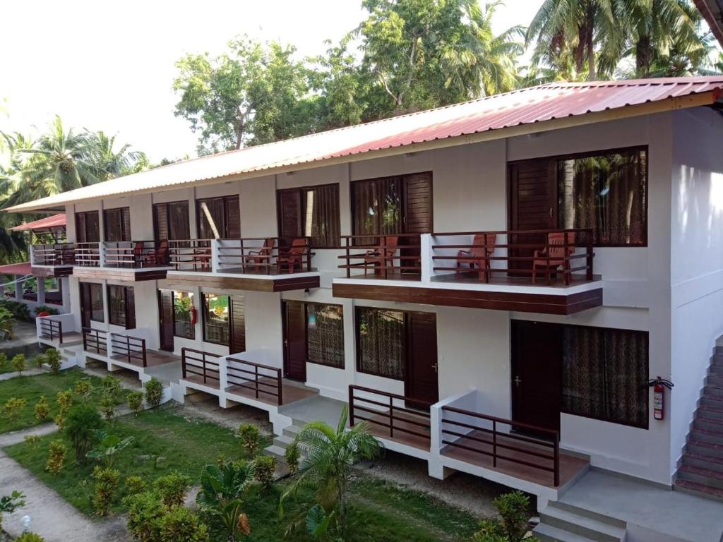 an apartment building with balconies and tables and chairs at Coconhuts Beach Resort in Neil Island