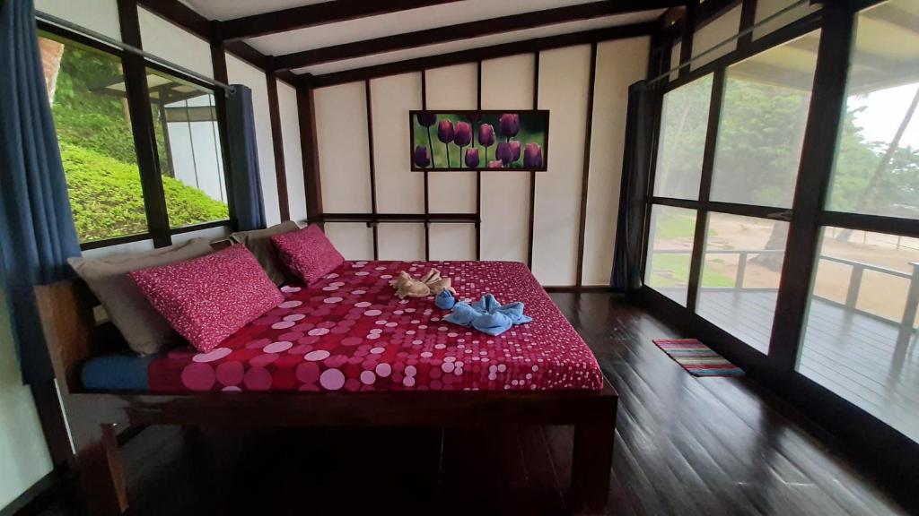 um quarto com uma mesa vermelha com flores em Duli Beach Resort em El Nido