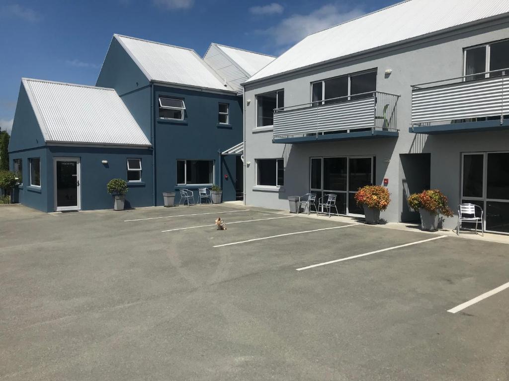 a dog in a parking lot in front of some buildings at Phoenix Motels in Temuka