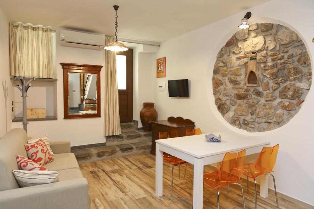 uma sala de estar com uma mesa branca e uma parede de pedra em Wine House (by Vacation Service) em Cefalù