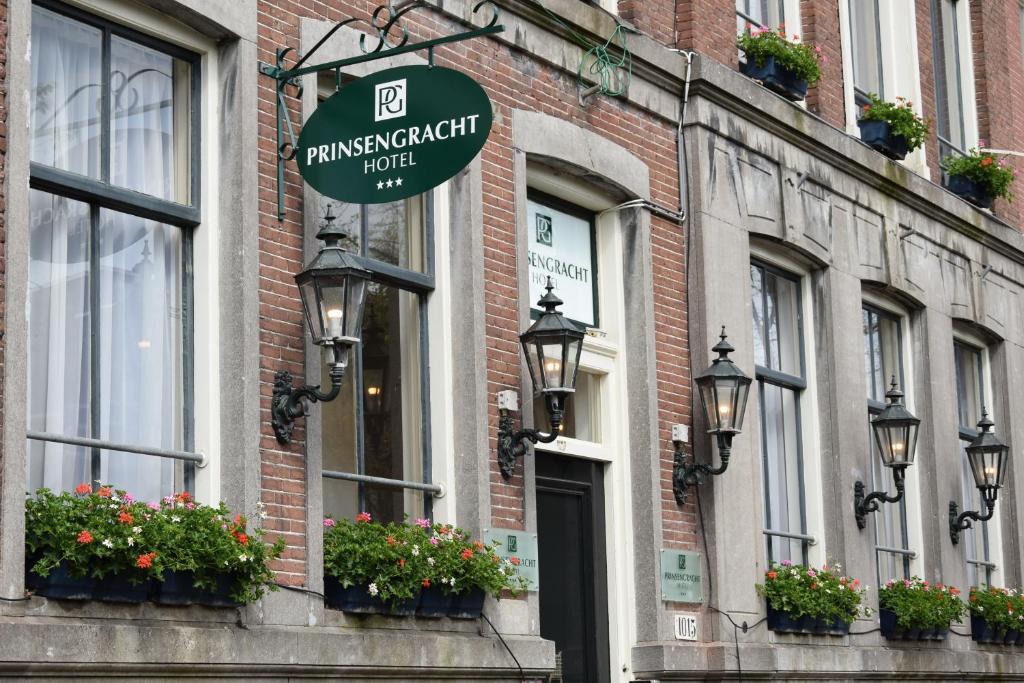 ein Schild an der Seite eines Gebäudes mit Blumen in der Unterkunft Prinsengracht Hotel in Amsterdam