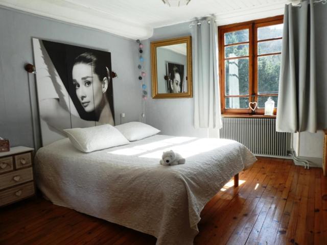 a bedroom with a bed with a teddy bear on it at Au Mange-Prunes in Auzon
