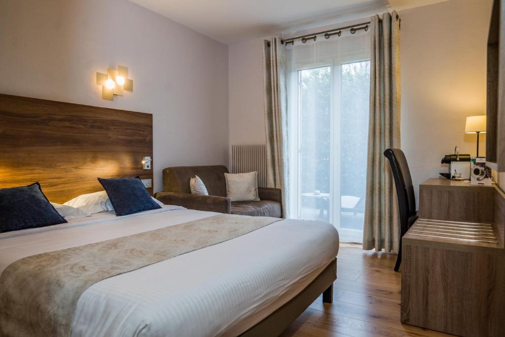 Postel nebo postele na pokoji v ubytování Logis Hotel Le Petit Casset