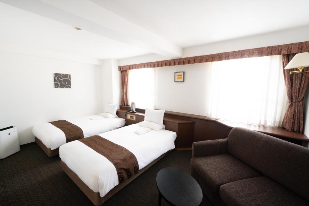 Postel nebo postele na pokoji v ubytování Toyo Hotel