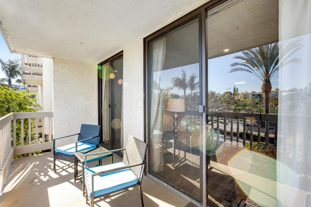 uma varanda com duas cadeiras e vista para o oceano em Modern condo with access to pool & hot tub in great location em Oceanside