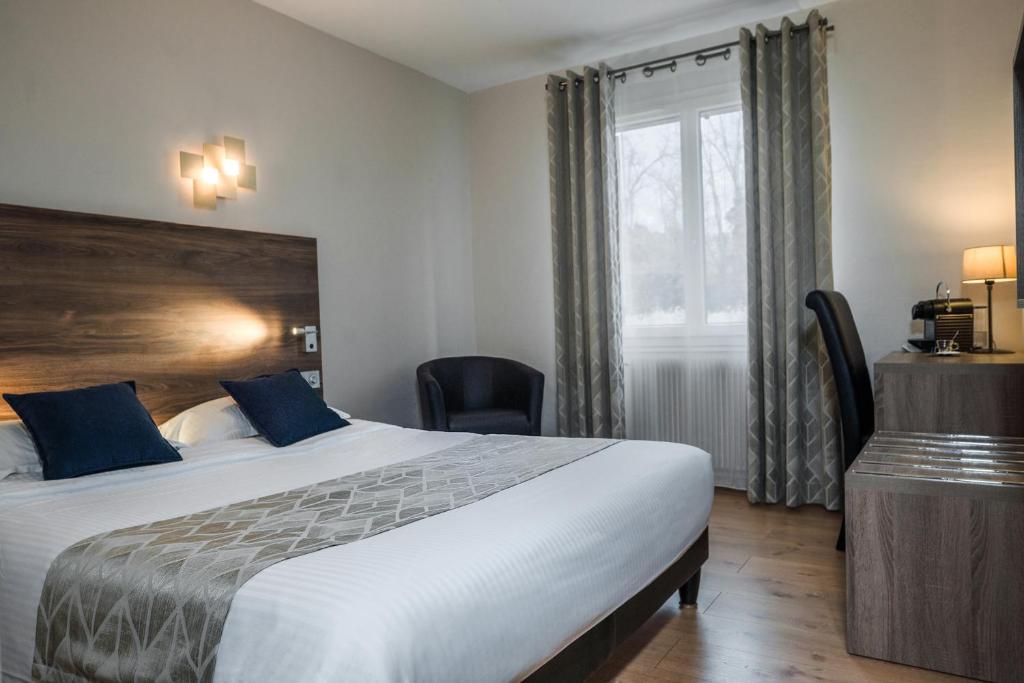Postel nebo postele na pokoji v ubytování Logis Hotel Le Petit Casset